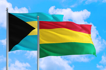 Bolivia and Bahamas national flag waving in the windy deep blue sky. Diplomacy and international relations concept.