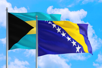 Bosnia Herzegovina and Bahamas national flag waving in the windy deep blue sky. Diplomacy and international relations concept.