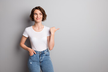 Photo of young attractive girl show point thumb empty space advertise promo recommend isolated over grey color background