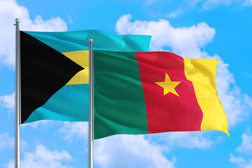 Cameroon and Bahamas national flag waving in the windy deep blue sky. Diplomacy and international relations concept.