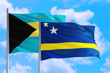 Curacao and Bahamas national flag waving in the windy deep blue sky. Diplomacy and international relations concept.