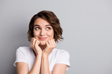 Photo of young cute girl wear casual outfit hands touch cheeks look empty space isolated over grey color background