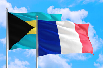 France and Bahamas national flag waving in the windy deep blue sky. Diplomacy and international relations concept.