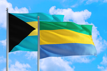 Gabon and Bahamas national flag waving in the windy deep blue sky. Diplomacy and international relations concept.