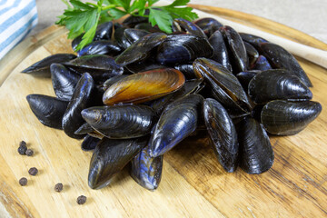 tas de moules crues sur une planche à découper