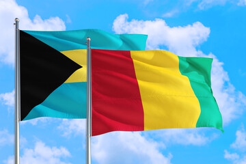 Guinea Bissau and Bahamas national flag waving in the windy deep blue sky. Diplomacy and international relations concept.
