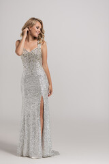 Attractive girl in a shiny evening dress made of diamonds.