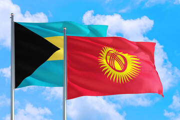 Kyrgyzstan and Bahamas national flag waving in the windy deep blue sky. Diplomacy and international relations concept.