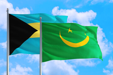 Mauritania and Bahamas national flag waving in the windy deep blue sky. Diplomacy and international relations concept.