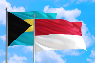 Monaco and Bahamas national flag waving in the windy deep blue sky. Diplomacy and international relations concept.