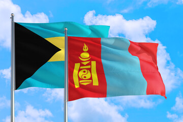 Mongolia and Bahamas national flag waving in the windy deep blue sky. Diplomacy and international relations concept.