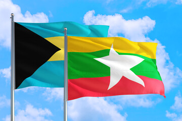 Myanmar and Bahamas national flag waving in the windy deep blue sky. Diplomacy and international relations concept.