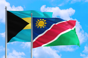 Namibia and Bahamas national flag waving in the windy deep blue sky. Diplomacy and international relations concept.