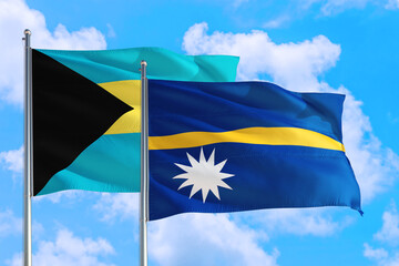 Nauru and Bahamas national flag waving in the windy deep blue sky. Diplomacy and international relations concept.