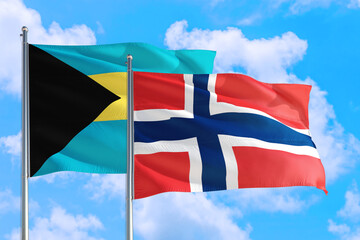 Norway and Bahamas national flag waving in the windy deep blue sky. Diplomacy and international relations concept.