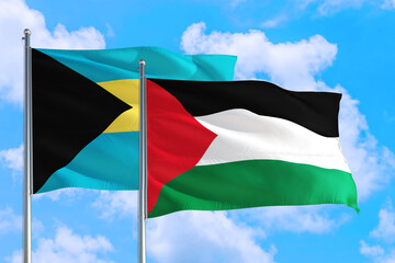 Palestine and Bahamas national flag waving in the windy deep blue sky. Diplomacy and international relations concept.