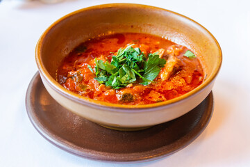 Georgian dish chakhohbili with pieces of chicken in ripe tomato sauce.