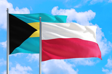 Poland and Bahamas national flag waving in the windy deep blue sky. Diplomacy and international relations concept.