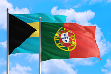 Portugal and Bahamas national flag waving in the windy deep blue sky. Diplomacy and international relations concept.