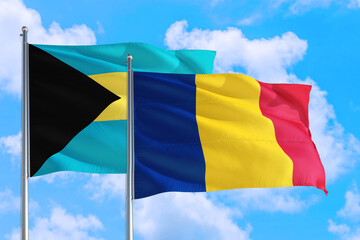Romania and Bahamas national flag waving in the windy deep blue sky. Diplomacy and international relations concept.