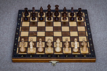 A wooden chess board with pawns