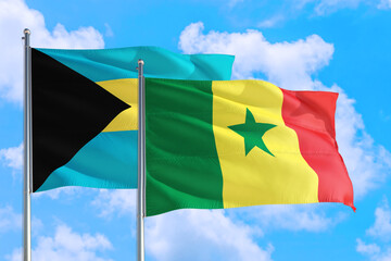 Senegal and Bahamas national flag waving in the windy deep blue sky. Diplomacy and international relations concept.