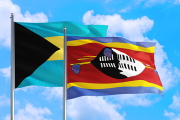 Swaziland and Bahamas national flag waving in the windy deep blue sky. Diplomacy and international relations concept.