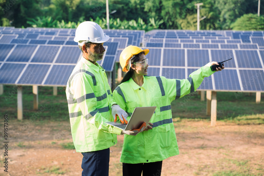 Poster Technicians and engineer in long sleeve shirts reflective vests and hard hats discussing something about solar panel power,Solar power plant to innovation of green energy for life.