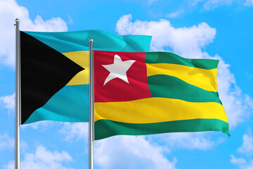 Togo and Bahamas national flag waving in the windy deep blue sky. Diplomacy and international relations concept.