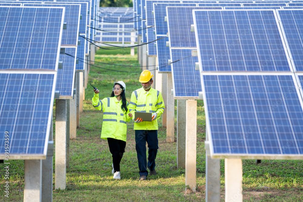 Poster engineer and technician checking equipment in solar panels for great efficiency.