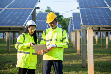 Technicians and engineer in long sleeve shirts reflective vests and hard hats discussing something about solar panel power,Solar power plant to innovation of green energy for life.