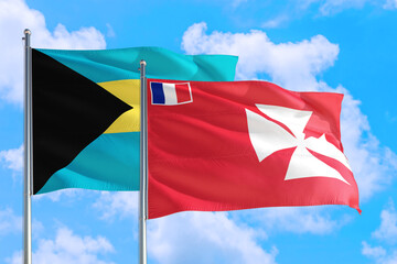 Wallis And Futuna and Bahamas national flag waving in the windy deep blue sky. Diplomacy and international relations concept.