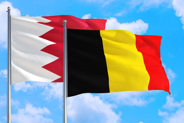 Belgium and Bahrain national flag waving in the windy deep blue sky. Diplomacy and international relations concept.