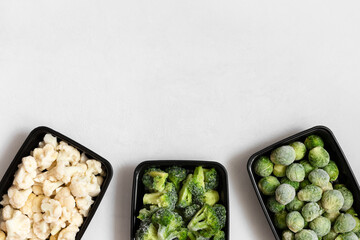 Frame of frozen vegetables in plastic containers on a white background. A set of different...
