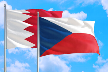 Czech Republic and Bahrain national flag waving in the windy deep blue sky. Diplomacy and international relations concept.