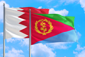 Fototapeta na wymiar Eritrea and Bahrain national flag waving in the windy deep blue sky. Diplomacy and international relations concept.