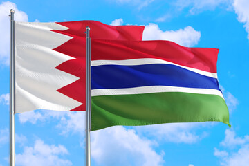 Gambia and Bahrain national flag waving in the windy deep blue sky. Diplomacy and international relations concept.