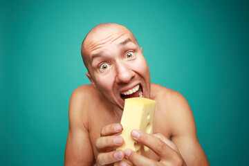 A funny bald man holding fresh cheese isolated on green background