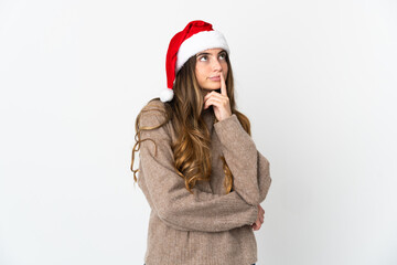 Caucasian girl with christmas hat isolated on white background having doubts while looking up