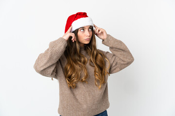 Caucasian girl with christmas hat isolated on white background having doubts and thinking