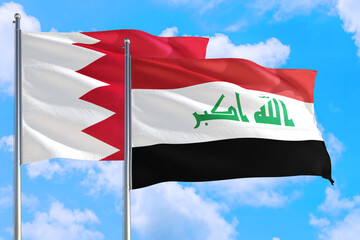 Iraq and Bahrain national flag waving in the windy deep blue sky. Diplomacy and international relations concept.