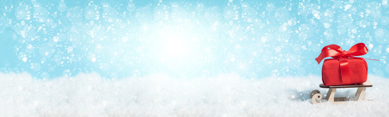 Banner with sleigh delivering Christmas or New Year red present box on blue snowed background