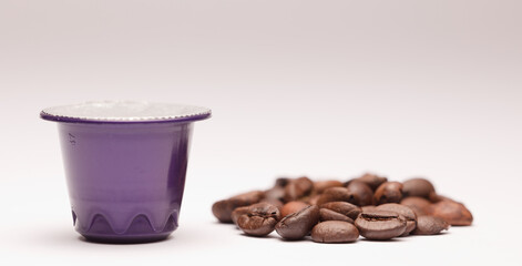 purple coffee capsule, with coffee beans, white background