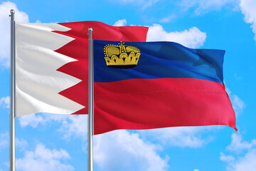 Liechtenstein and Bahrain national flag waving in the windy deep blue sky. Diplomacy and international relations concept.