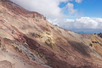 Mountain slope at a high altitude showing the red, yellow, grey and white vulcanic substrate of the chimborazo vulcano in Ecuador