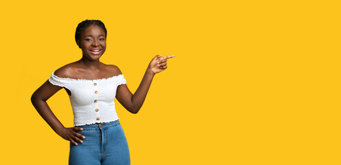 Check This. Cheerful Black Lady Pointing At Copy Space Over Yellow Background