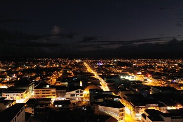 Fototapeta na wymiar Aerial view of a city at night showing the many buildings being lit and a the bright mainstreet 