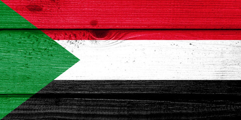 Sudan flag painted on old wood plank background. Brushed natural light knotted wooden board texture. Wooden texture background flag of Sudan