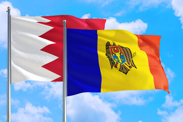 Moldova and Bahrain national flag waving in the windy deep blue sky. Diplomacy and international relations concept.