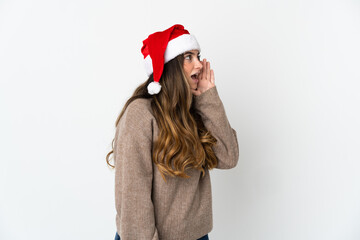 Caucasian girl with christmas hat isolated on white background shouting with mouth wide open to the side